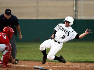 Baseball players sliding into home base