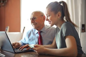 Volunteer showing a Booster Club Crowdfunding Fundraiser to a elderly supporter