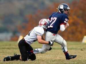 Football team player getting tackled in game