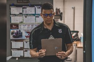 Soccer coach looking at strategies on clipboard