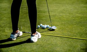 School golf team member practicing putting 