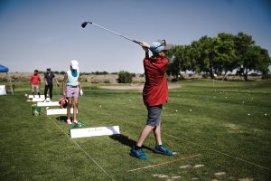 High School golf team members practicing at driving range