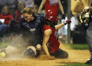 Softball player sliding into home plate