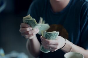 Booster club supporter counting money after a fundraiser.